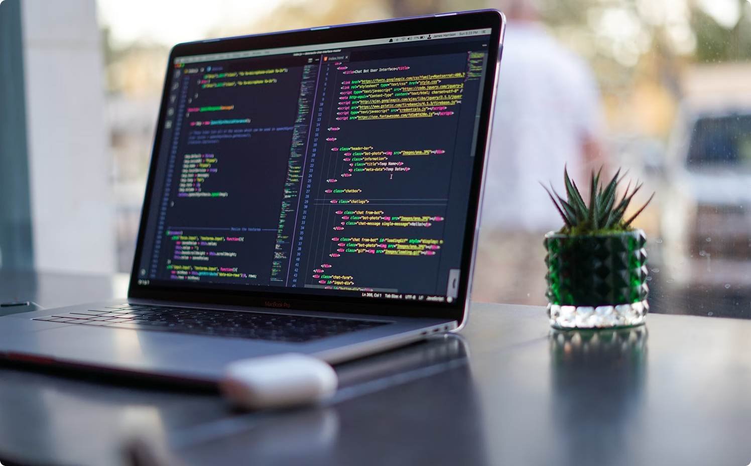 Laptop with code on the screen with a background of a clear window