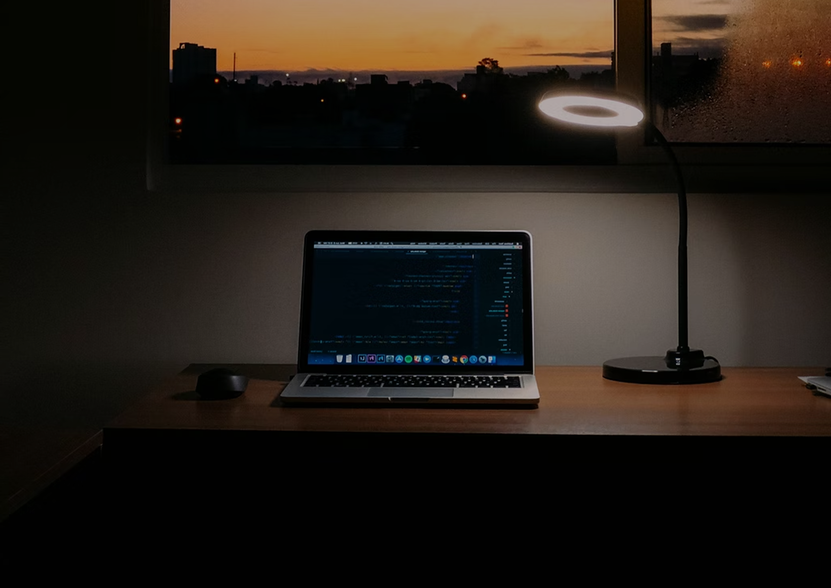Laptop with code on the screen sitting in a dark room.